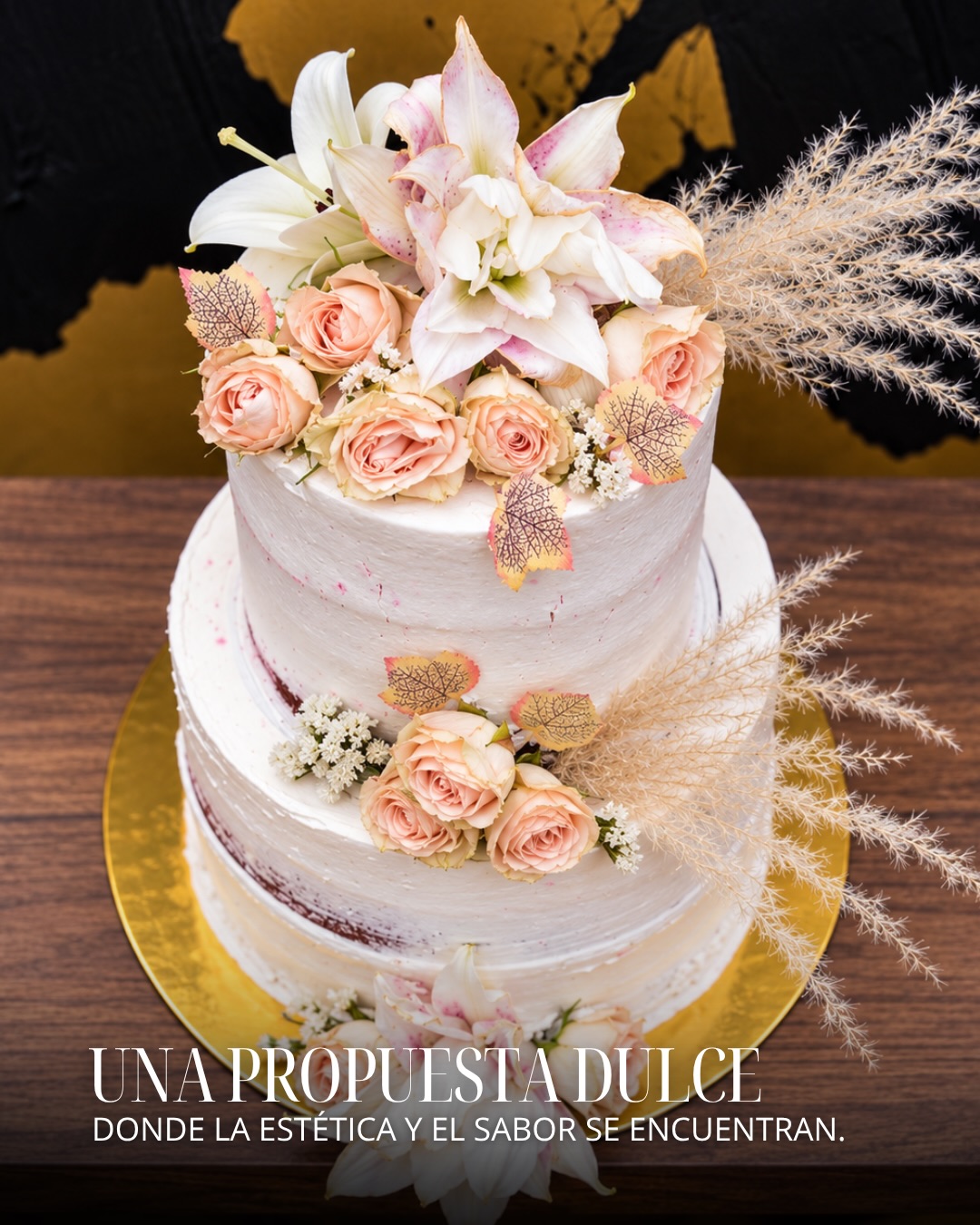 Fotografía de Singular: torta decorada con flores claras, rosas y detalles dorados.